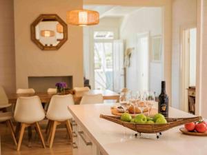 a kitchen with a table with a basket of fruit and wine glasses at Driftwood Beach House in Kiama +46 photos