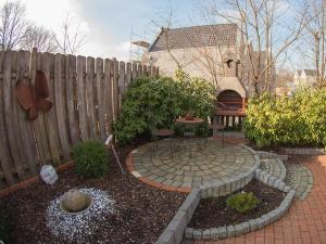 een tuin met een vuurplaats voor een hek bij Ferienhaus Leifert, FeWo Vermittlung Nordsee in Dangast