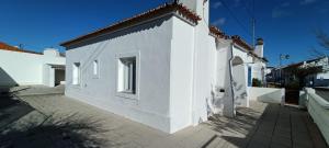 a white building with a window on the side of it at Casa do Bairro 21 in Portel