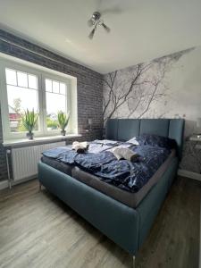 Una cama azul en un dormitorio con una pared de ladrillo en Ferienhaus Markus - Grömitz OT Brenkenhagen en Grömitz