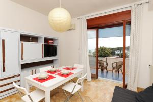 cocina y sala de estar con mesa blanca y sillas en Tizi Apartments en Maiori