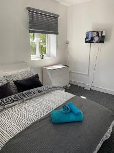een slaapkamer met een bed met een blauwe handdoek erop bij Lovely 2 bedroom flat in greater london in Londen