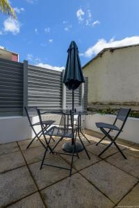 a table with two chairs and an umbrella on a patio at City Cocoon T2 rénové proche centre Saint Denis in Saint-Denis