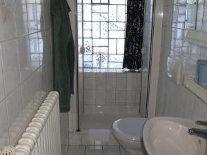 a bathroom with a sink and a toilet and a window at Ferienwohnung Stadtblick in Bräunlingen