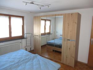 a bedroom with a bed and a glass closet at Ferienwohnung Stadtblick in Bräunlingen