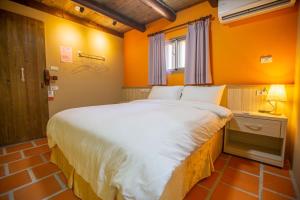 un grande letto in una stanza con pareti arancioni di King of Thailand a Jinhu