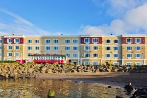 un gran edificio con una bandada de aves cerca del agua en Holiday Inn Express Hotel & Suites Astoria, an IHG Hotel en Astoria, Oregon