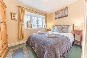 a bedroom with a bed with two towels on it at Waingarth Cottage Grizedale Forest & Satterthwaite in Ulverston