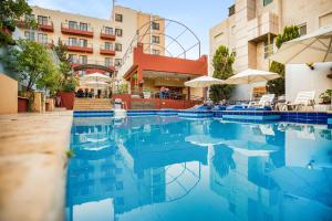 a swimming pool in front of a hotel at Grand Hotel Madaba in Madaba