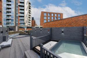 - un balcon avec un bain à remous au-dessus d'un bâtiment dans l'établissement Brand New London Luxury House - Sleeps 8, à Londres