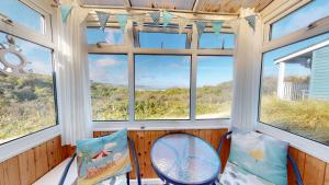 a screened in porch with two chairs and windows at C15 Seamore, Riviere Towans in Hayle