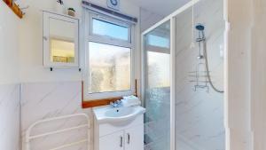 a bathroom with a sink and a window and a shower at C15 Seamore, Riviere Towans in Hayle +18 photos
