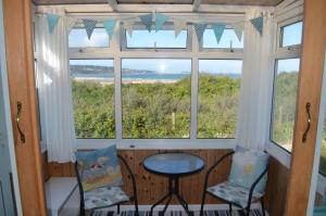 a room with two chairs and a window at C15 Seamore, Riviere Towans in Hayle