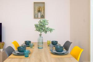 - une table à manger avec des plats bleus et un vase dans l'établissement City Cocoon T2 rénové proche centre Saint Denis, à Saint-Denis