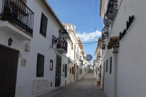 an alley with white buildings and a blue sky at La Cueva in Altea