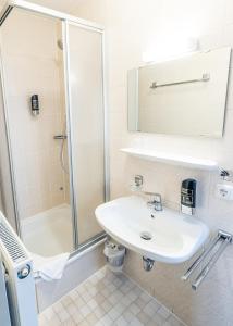 a bathroom with a sink and a shower at Gasthaus Kampenwand Bernau in Bernau am Chiemsee