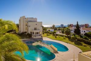 - une vue sur la piscine en face d'un bâtiment dans l'établissement Quinta dos Arcos 2BR w/ AC & Pool by LovelyStay, à Alvor