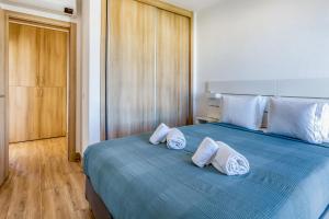 - une chambre avec un lit bleu et des oreillers blancs dans l'établissement Quinta dos Arcos 2BR w/ AC & Pool by LovelyStay, à Alvor