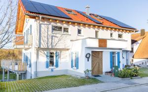 a white house with solar panels on its roof at Homely in Heidenheim an der Brenz