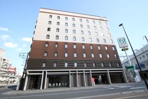 a tall building on a city street at Green Rich Hotel Hiroshima Shinkansenguchi (Artificial hot spring Futamata Yunohana) in Hiroshima