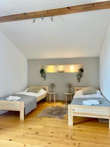 a bedroom with two beds and two tables at Apartament Na Skarpie in Nowy Targ