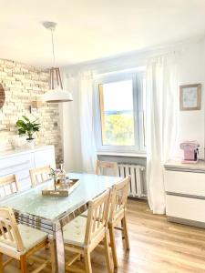 a dining room with a table and chairs in a kitchen at Apartament Na Skarpie in Nowy Targ
