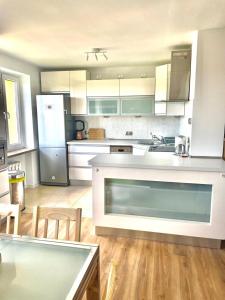a large kitchen with white appliances and wooden floors at Apartament Na Skarpie in Nowy Targ