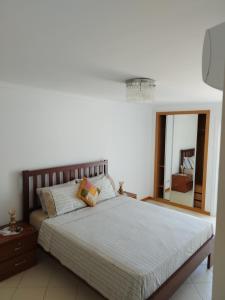 a bedroom with a large bed and a mirror at Mar & Morna in Mindelo