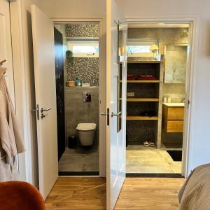 a bathroom with a shower and a toilet in a room at Bed and Breakfast De Beekhoek in Glane