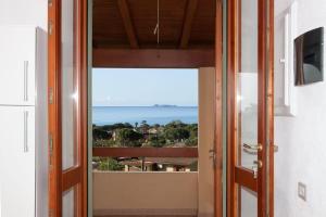 una porta che conduce a un balcone con vista sull'oceano di Sun & Beach house Costa Rei a Costa Rei