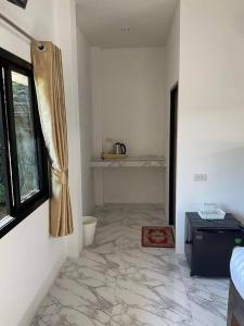 a white room with a marble floor and a window at Family Hut Pai in Pai