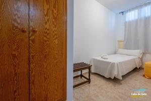 1 dormitorio con 1 cama y armario de madera en Calilla de San José, en San José