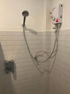 una ducha con una manguera pegada a la pared en Family Hut Pai, en Pai