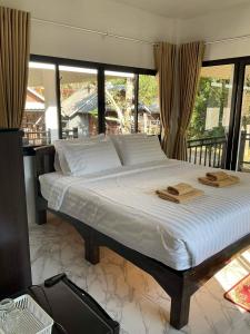 a bedroom with a large bed with two towels on it at Family Hut Pai in Pai