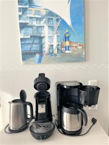 deux photos d'une cafetière sur un comptoir dans l'établissement Apartmenthaus Hafenspitze Ap 37 "Sonnendeck", Blickrichtung von der Terrasse auf das Offenes Meer, Strand, Innenstadt, à Eckernförde