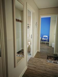 un couloir avec un miroir et une chambre avec une chaise dans l'établissement Apartmenthaus Hafenspitze Ap 37 "Sonnendeck", Blickrichtung von der Terrasse auf das Offenes Meer, Strand, Innenstadt, à Eckernförde