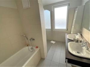 La salle de bains est pourvue d'une baignoire, d'un lavabo et d'une baignoire. dans l'établissement Apartmenthaus Hafenspitze Ap 37 "Sonnendeck", Blickrichtung von der Terrasse auf das Offenes Meer, Strand, Innenstadt, à Eckernförde