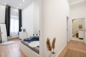 布達佩斯的住宿－Budapest Eye Residence，一间拥有白色墙壁的卧室和一张位于客房内的床