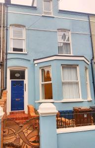 una casa azul con una puerta y ventanas azules en Bangor Central Apartments en Bangor