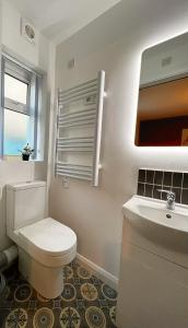 a bathroom with a white toilet and a sink at Bangor Central Apartments in Bangor