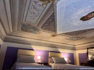 フィレンツェにあるApartments Pucciniのベッド2台と天井が備わる客室です。