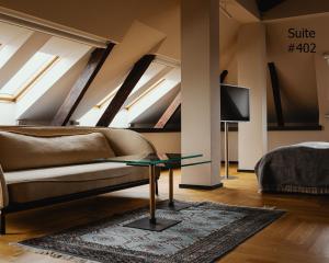 ein Wohnzimmer mit einem Sofa und einem TV in der Unterkunft Hotel Pod Różą in Krakau