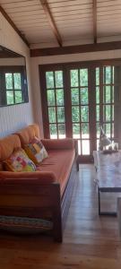 una sala de estar con sofá en una habitación con ventanas en Cabaña La Colmena en Tigre