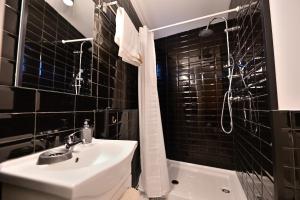 a black tiled bathroom with a sink and a shower at 4 Mares Apartamentos M in Loredo +14 photos