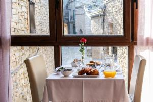 a table with a plate of food and orange juice at El Forn de Freixenet con servicios de un hotel in Lleida