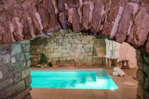 una piscina di fronte a un muro di pietra di El Forn de Freixenet con servicios de un hotel a Lleida