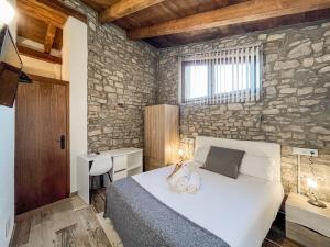 A bed or beds in a room at El Forn de Freixenet con servicios de un hotel