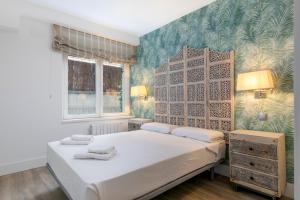 um quarto com uma cama branca e uma parede verde em HOMEABOUT RÍOS ROSAS APARTMENT em Madrid
