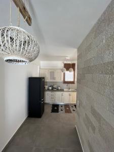 a kitchen with a black refrigerator and a brick wall at White Villas Paros in Kampos Paros