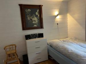 a bedroom with a bed and a dresser and a picture at Holiday home Brandasund II in Rolvsnes